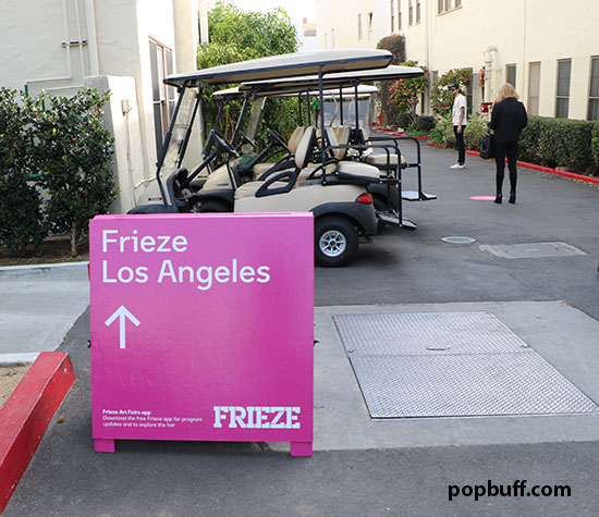 A galore of fuschia pink signs that say Frieze Los Angeles