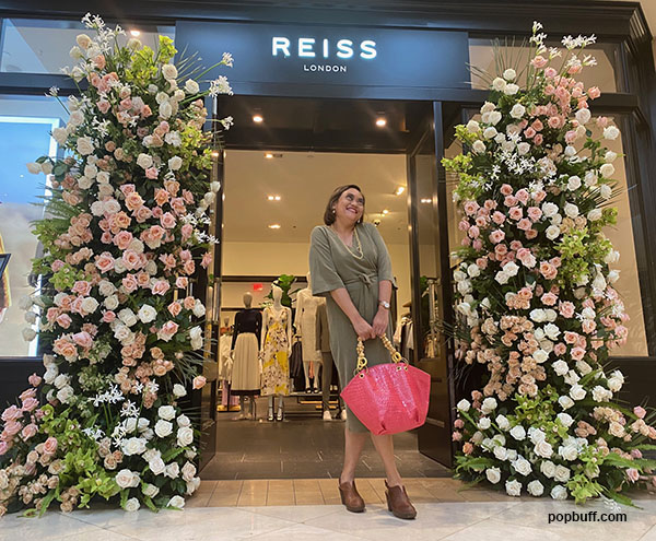 Popbuff blogger Ruchel Freibrun stands  in front of the Reiss' floral display at the Fleurs de Villes VOYAGE in South Coast Plaza Costa Mesa - Popbuff.com